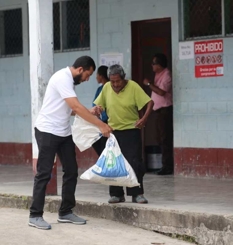 Henrry Pocasangre, enviado especial de Prensa Libre, apoya a don Magdaleno Chún al momento de salir del centro de votación en San Luis Petén. (Foto Prensa Libre: Érick Ávila)