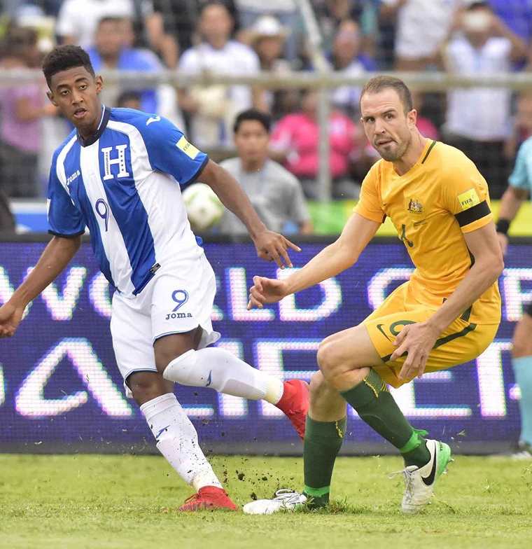 El jugador de Honduras Lozano (i) disputa un balón frente al jugador australiano Matthew Jurman. (Foto Prensa Libre: EFE)