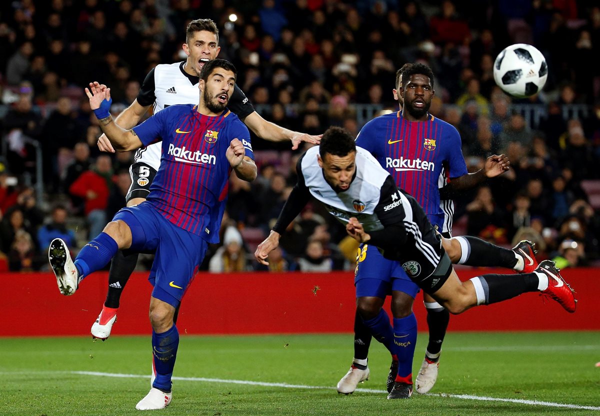 El centrocampista del Valencia Coquelin (c) cabecea ante Luis Suárez (i) y Umtiti, ambos del FC Barcelona. (Foto Prensa Libre: EFE)