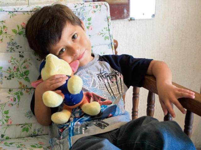 Adrián González abraza uno de sus juguetes favoritos mientras los padres relatan su historia.