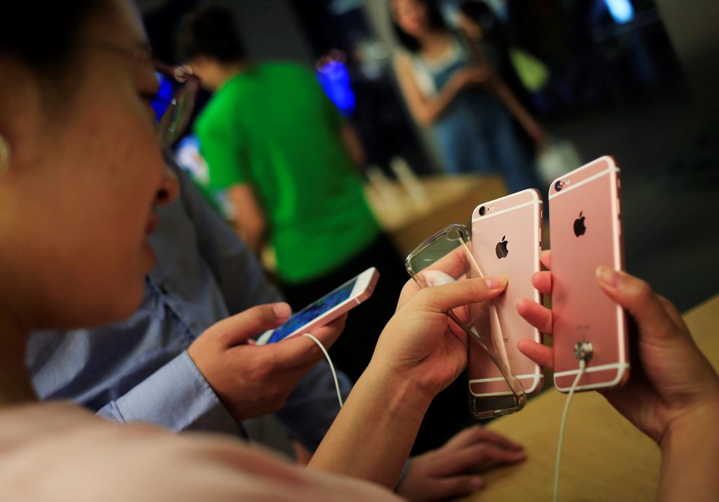 Una cliente observa un iPhone 6 en una tienda Apple en Pekín, China. (Foto Prensa Libre: EFE)