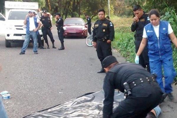 Investigadores cubren el cadáver de Orlando Revolorio Godoy, quien murió baleado en Mazatenango, Suchitepéquez. (Foto Prensa Libre: Omar Méndez)