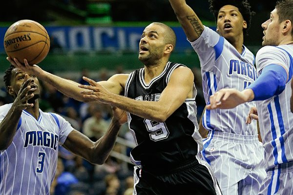 Tony Parker —en el centro— trata de hacer un tiro durante el duelo de esta noche. (Foto Prensa Libre: AP)