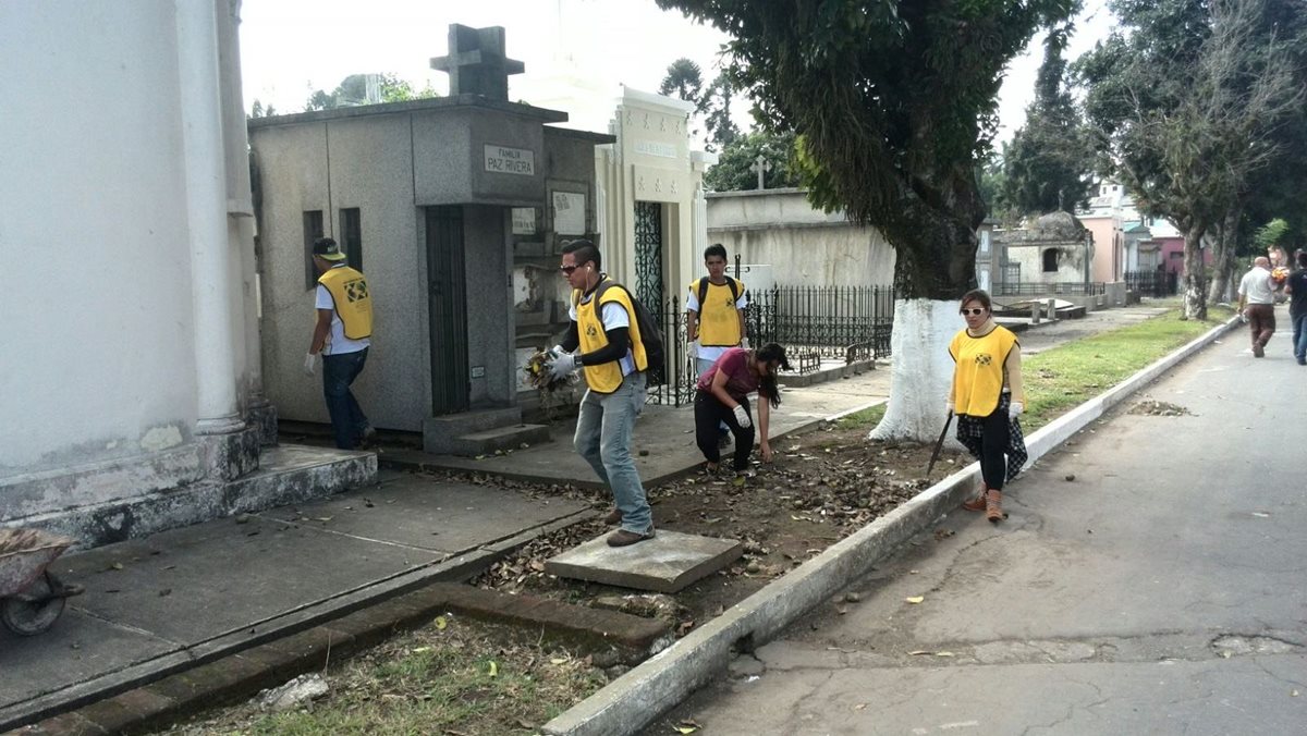 Voluntarios limpian el Cementerio General. (Foto Prensa Libre: Henry Pocasangre)