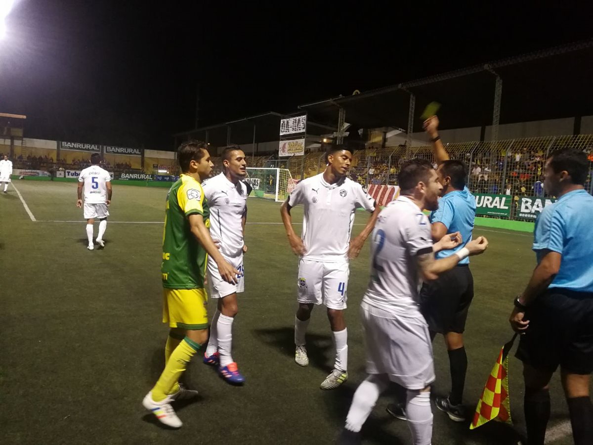 Mientras jugadores reclaman un fuera de lugar el árbitro muestra tarjeta amarilla. (Foto Prensa Libre: Edwin Fajardo)