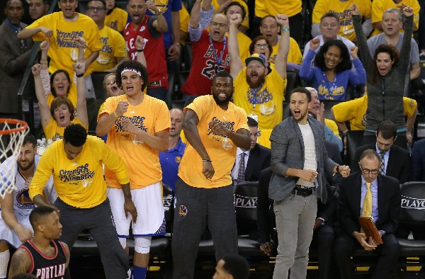 El jugador de los Warriors, Stephen Curry, derecha, reacciona tras una jugada en la serie con Portland Trail Blazers. (Foto Prensa Libre: AFP)