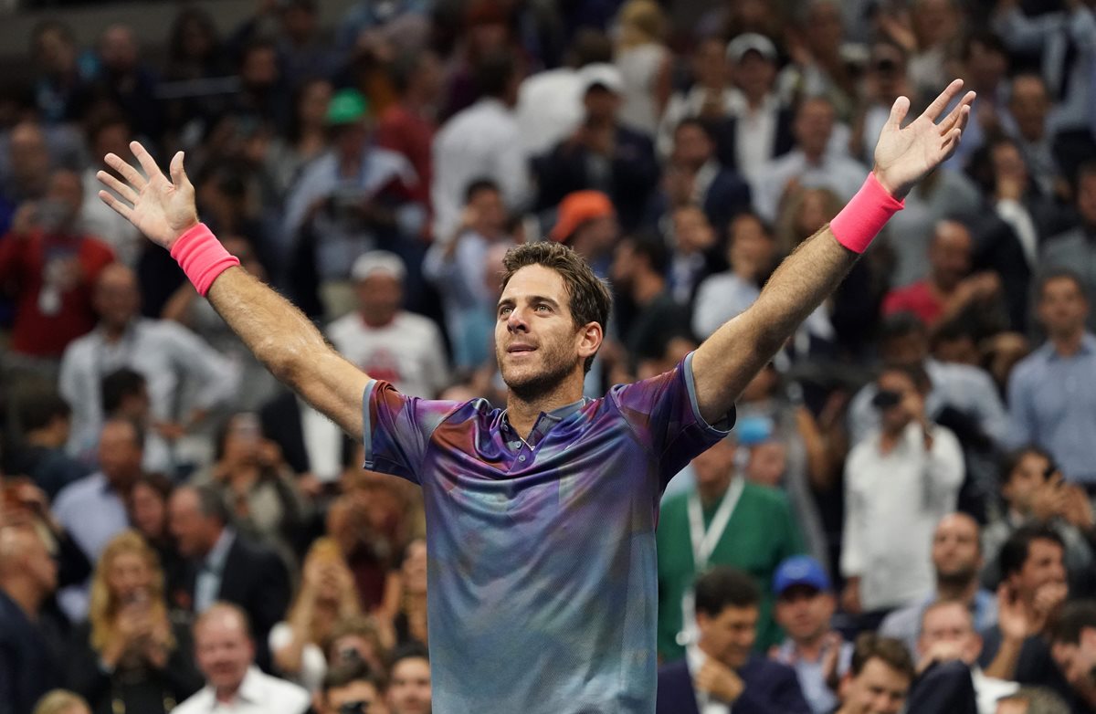 El argentino Juan Martín del Potro abre los brazos y celebra después de derrotar al suizo Roger Federer. (Foto Prensa Libre: AFP)