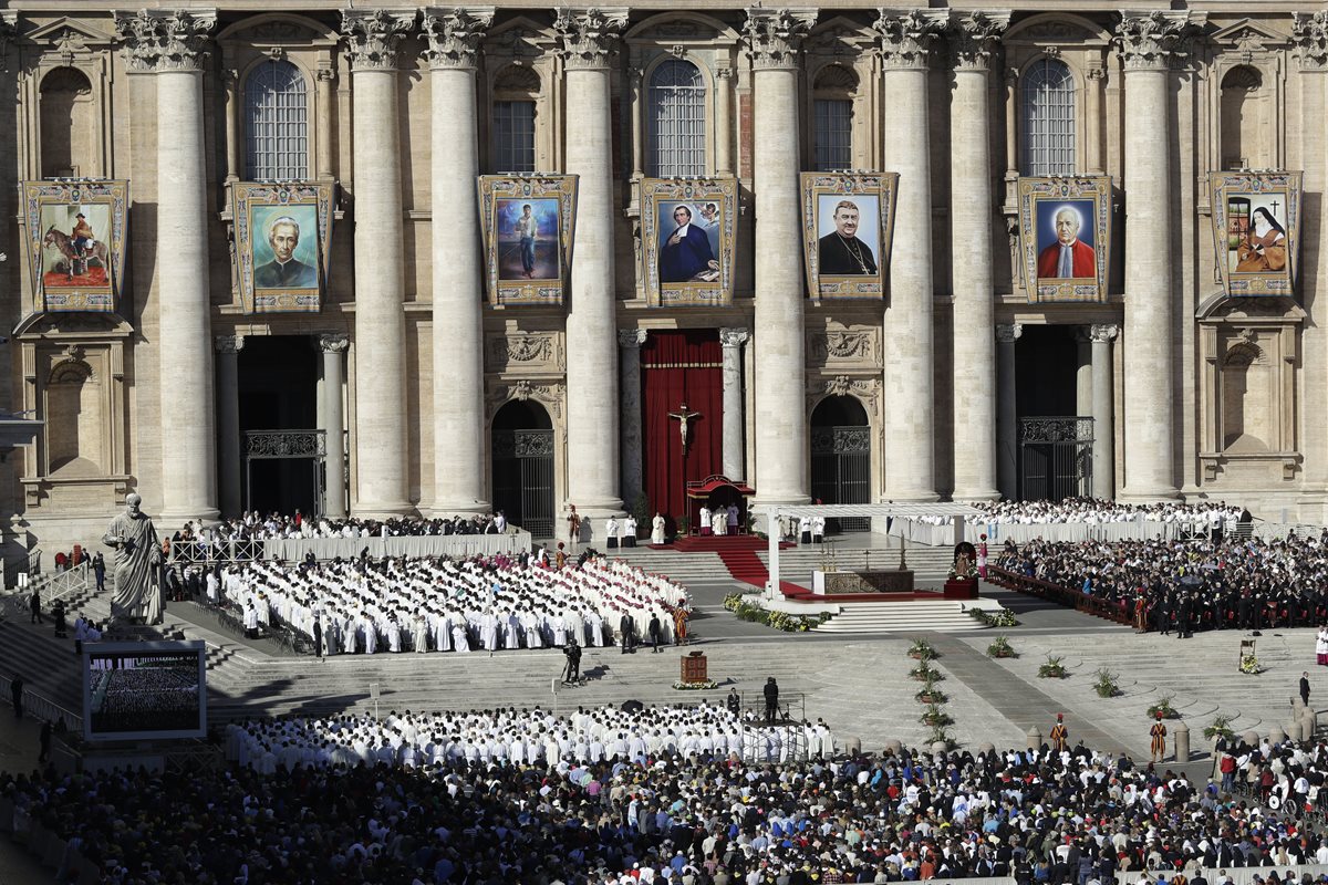 En la fachada de la Basílica de San Pedro se ven las fotos o ilustraciones de los siete nuevos santos. (Foto Prensa Libre: AFP)