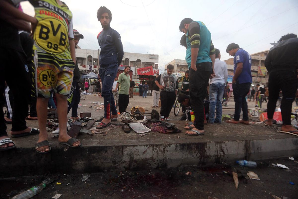 Iraquíes observan el lugar donde ocurrió el atentado. (Foto Prensa Libre: EFE).