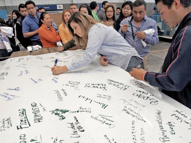 Colaboradores de Prensa Libre firman una gigantesca manta en donde plasman diversidad de valores que no cambiarán en este medio de comunicación. (Foto Prensa Libre)