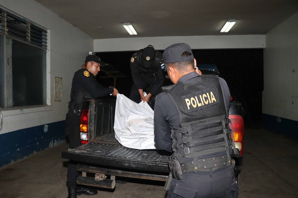 Agentes de la Policía Nacional Civil trasladan los cuerpos de dos hombres linchados en San Marcos Palajunoj, El Palmar, Quetzaltenango. (Foto Prensa Libre: Rolando Miranda)