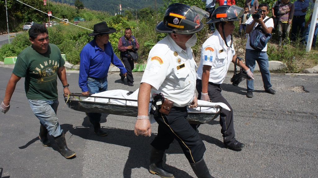 Socorristas trasladan el cadáver al Inacif de Quetzaltenango.(Foto Prensa Libre: Ángel Julajuj).