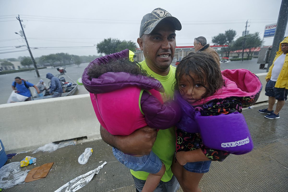 Un rescatista traslada a dos niños Un  después de ser rescatado en Houston.(AP).