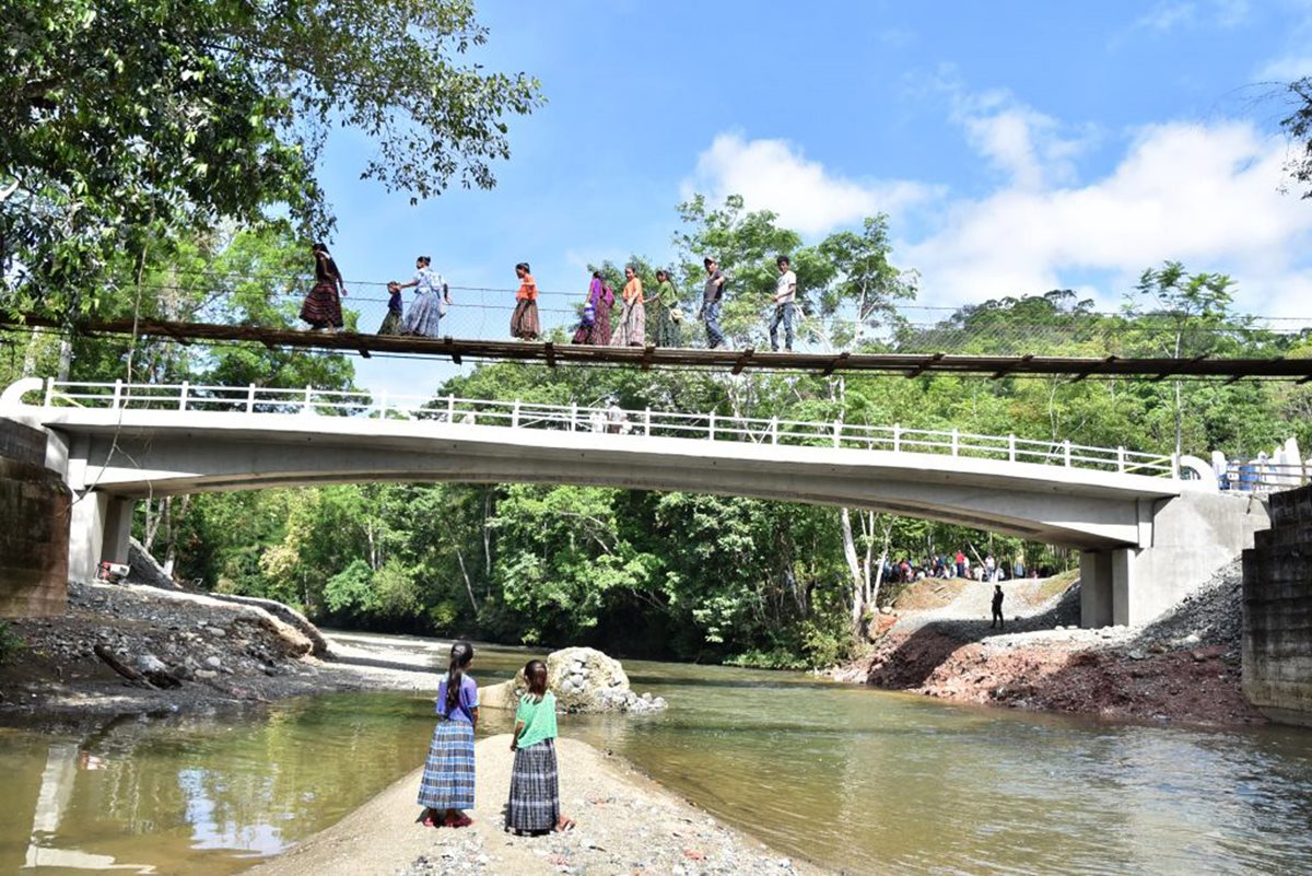 Un grupo de pobladores cruzan el antiguo puente de hamaca mientras que otro permanece sobre la nueva estructura, en la comunidad q’eqchi’ Nimlabenqué, El Estor, Izabal. (Foto Prensa Libre: Dony Stewart)