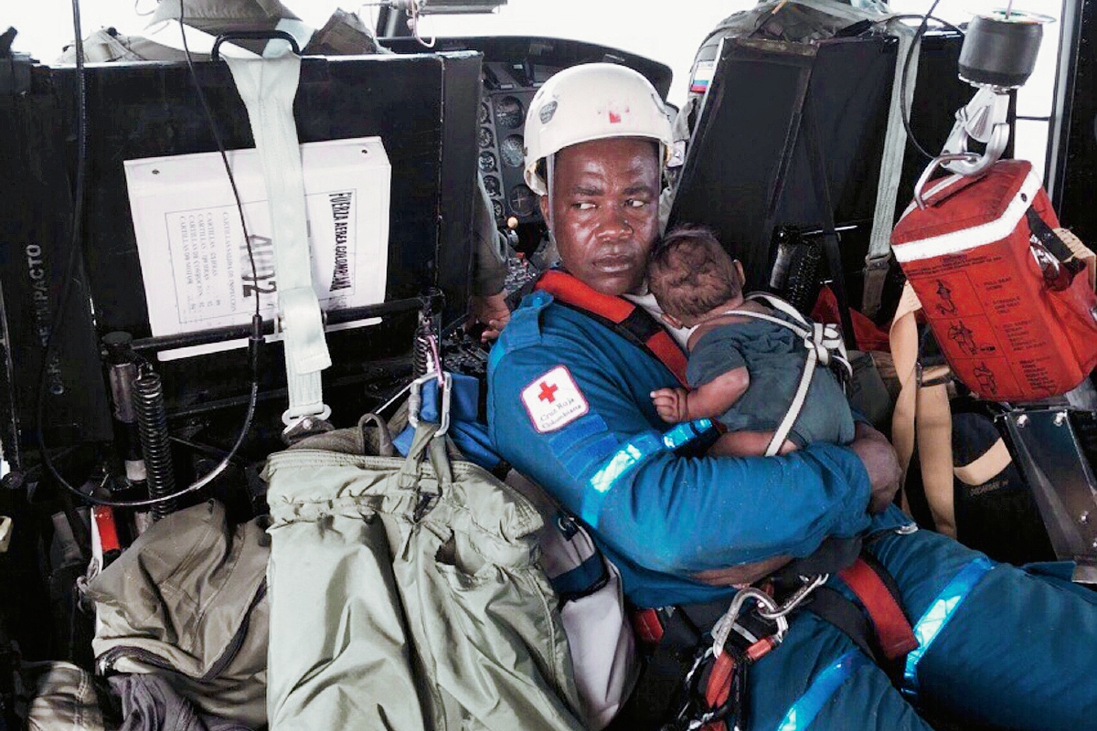 Ascisclo Rentería, el “héroe” colombiano sostiene en brazos al bebé que fue rescatado tras permanecer cinco días perdido en la selva con su madre. (Foto Prensa Libre: AFP).