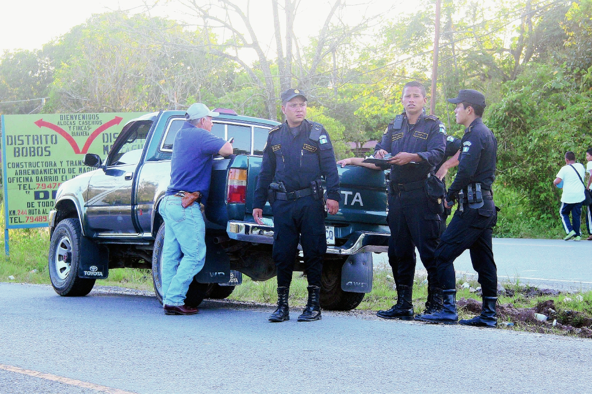 Agentes de  la PNC revisan documentos de un automovilista durante  un operativo en Izabal. (Foto Prensa Libre: Edwin Perdomo)