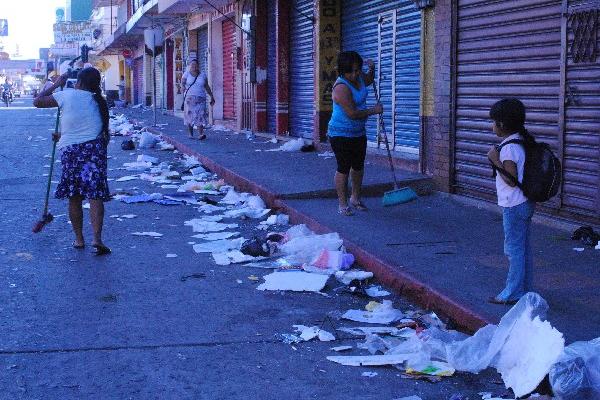 Vecinas barren una calle de Coatepeque, para retirar la basura que quedó  por  fiesta de fin de año.