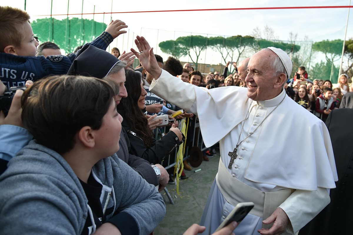 El papa Francisco saluda a niños y jóvenes en una visita a una comunidad cercana a Roma. (Foto Prensa Libre: AFP)