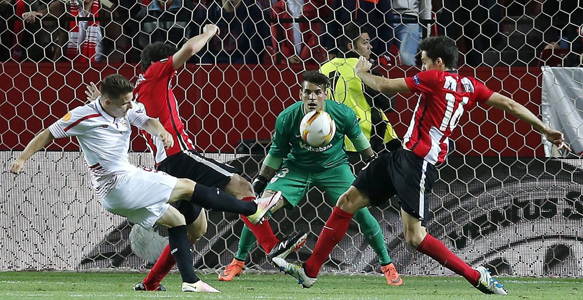El delantero francés del Sevilla, Kevin Gameiro (i), golpea el balón ante los defensas y el guardameta del Athletic de Bilbao. (Foto Prensa Libre: EFE)
