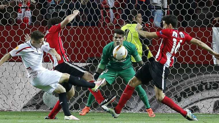 El delantero francés del Sevilla, Kevin Gameiro (i), golpea el balón ante los defensas y el guardameta del Ath de Bilbao. (Foto Prensa Libre: EFE)