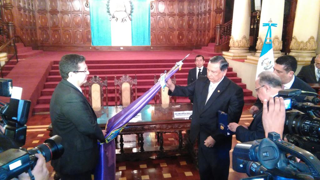 Fuentes Soria coloca las insignias de la Orden del Quetzal a la bandera de la Facultad de Odontología. (Foto Prensa Libre: Geovanni Contreras)