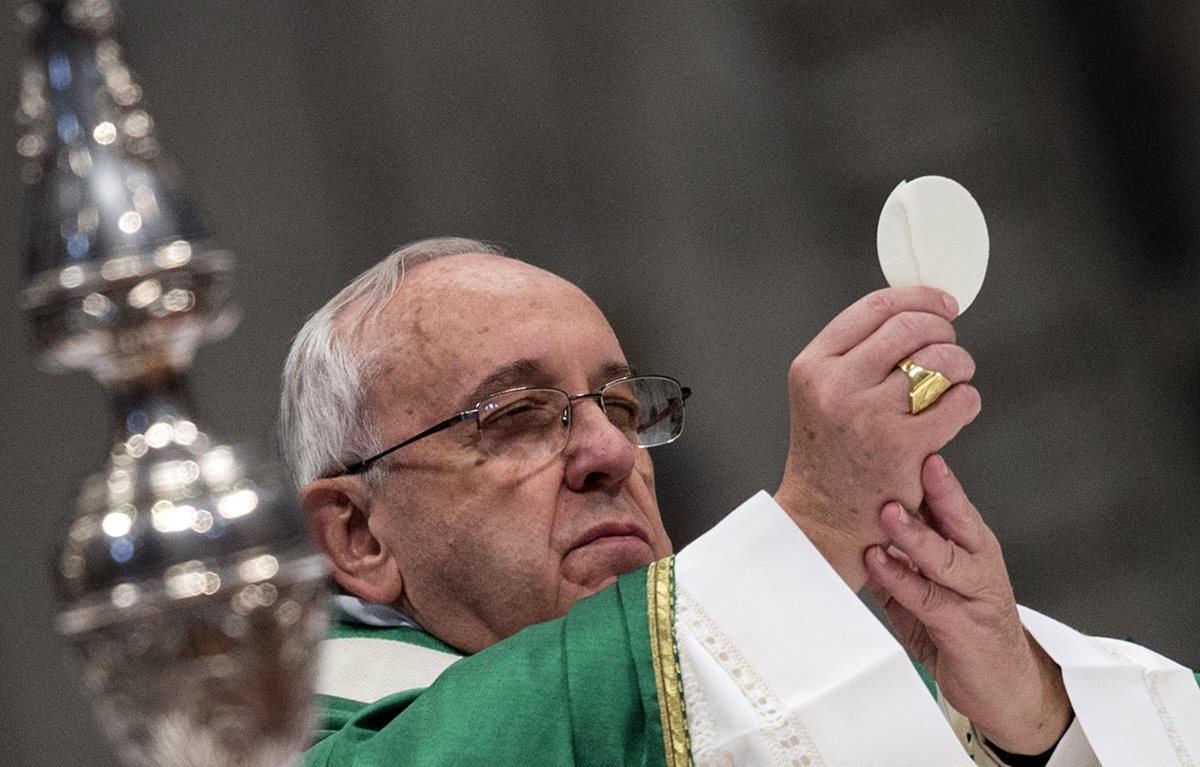 El Papa sostiene la Eucaristía antes de dar la Santa Comunión en la Basílica de San Pedro, Ciudad del Vaticano. (Foto Prensa Libre: AP).