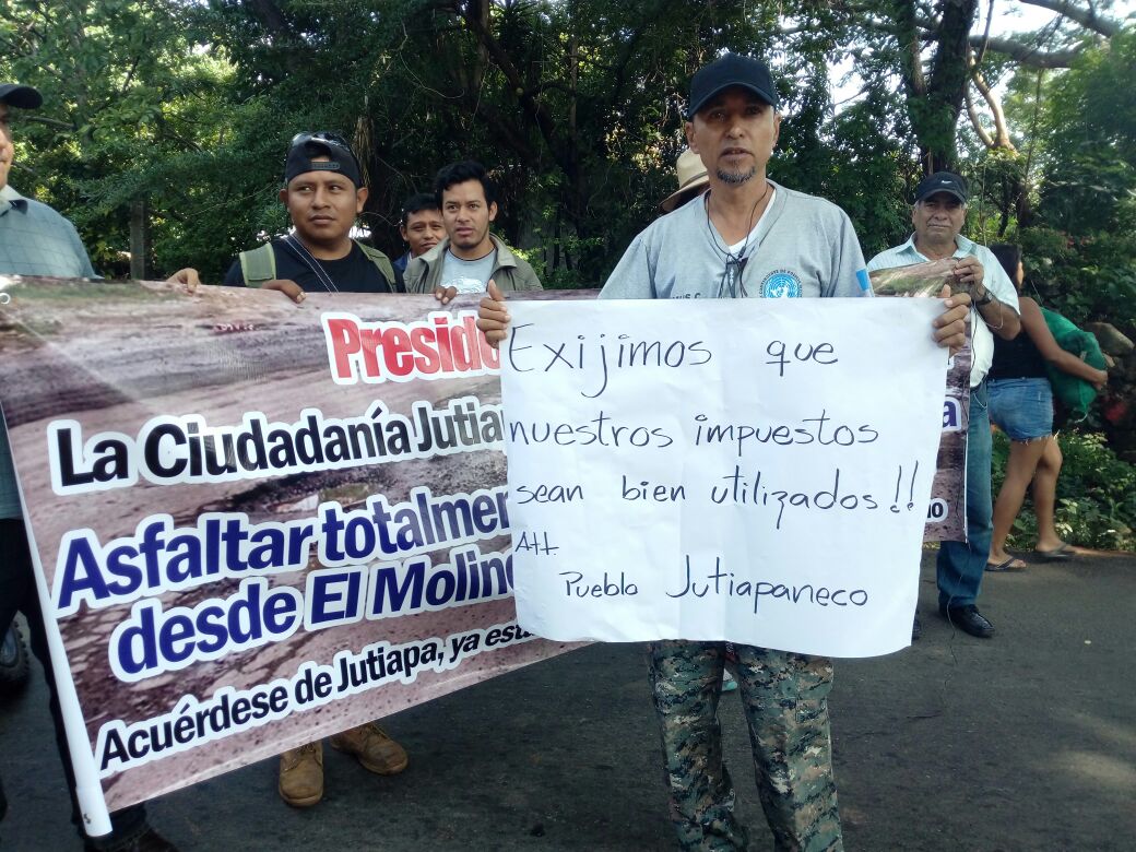 Vecinos bloqueoron de la carretera en El Arenal, Asunción Mita, con carteles en mano. (Foto Prensa Libre: Óscar González)