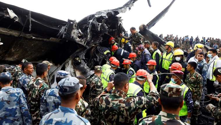Socorristas rescataron los cadáveres de 40 personas que murieron dentro del avión que se accidentó en Katmandú. (Foto Prensa Libre: EFE)