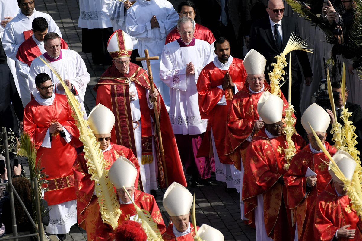 El papa Francisco (centro) dirige las celebraciones del Domingo de Ramos en la plaza de San Pedro. (Foto Prensa Libre:AFP).
