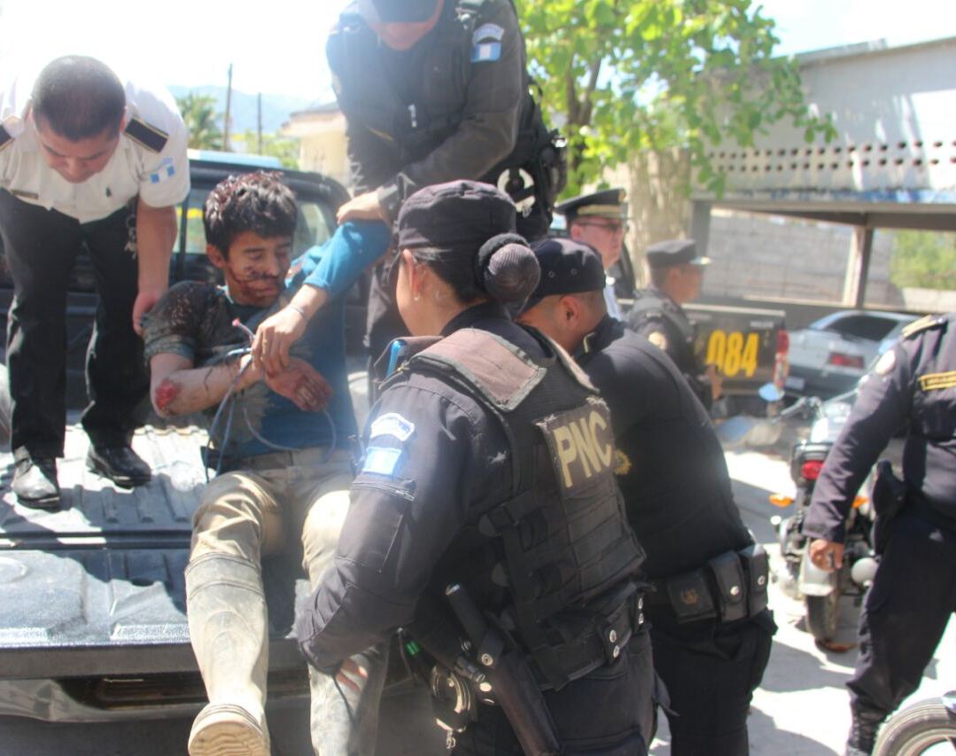 Uno de los sospechosos de haber violado y asesinado a una menor de 12 años en Camotán, mientras lo suben a un autopatrulla. (Foto Prensa Libre: Mario Morales)