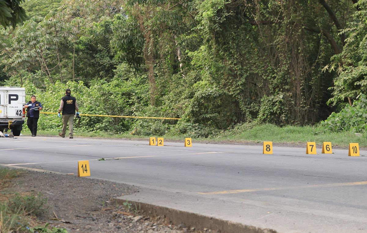 Investigadores reúnen indicios en el kilómetro 98 de la autopista a Puerto Quetzal, Escuintla, donde fueron ultimados dos presuntos delincuentes. (Foto Prensa Libre: Enrique Paredes).