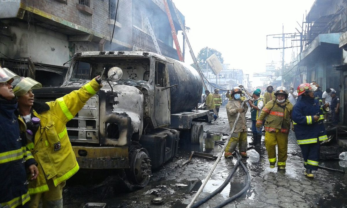 Bomberos controlan el siniestro en el vehículo e inmuebles cercanos. (Foto Prensa Libre: Alexander Coyoy)
