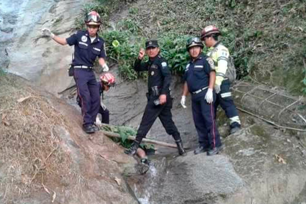 Socorristas resguardan el cuerpo del joven que murió al caer accidentalmente en un riachuelo. (Foto Prensa Libre: Whitmer Barrera)