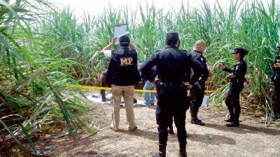Agentes de la PNC y peritos del MP recogen evidencia en el lugar del hallazgo. (Foto Prensa Libre: Jorge Rolando Miranda)