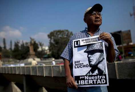 Un hombre porta un cartel que niega el genocidio. (Foto Prensa Libre: EFE)
