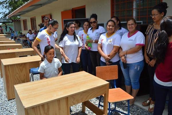 Maestras de la Escuela Oficial Mixta Hernaldo Beltrán, de Gualán, permanecen junto a parte del mobiliario donado. (Foto Prensa Libre: Víctor Gómez)