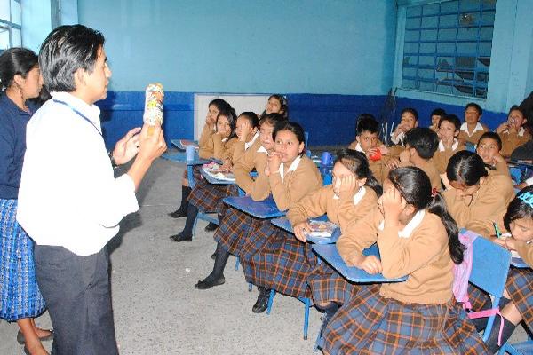 Coordinador explica cómo rellenar una botella de plástico.