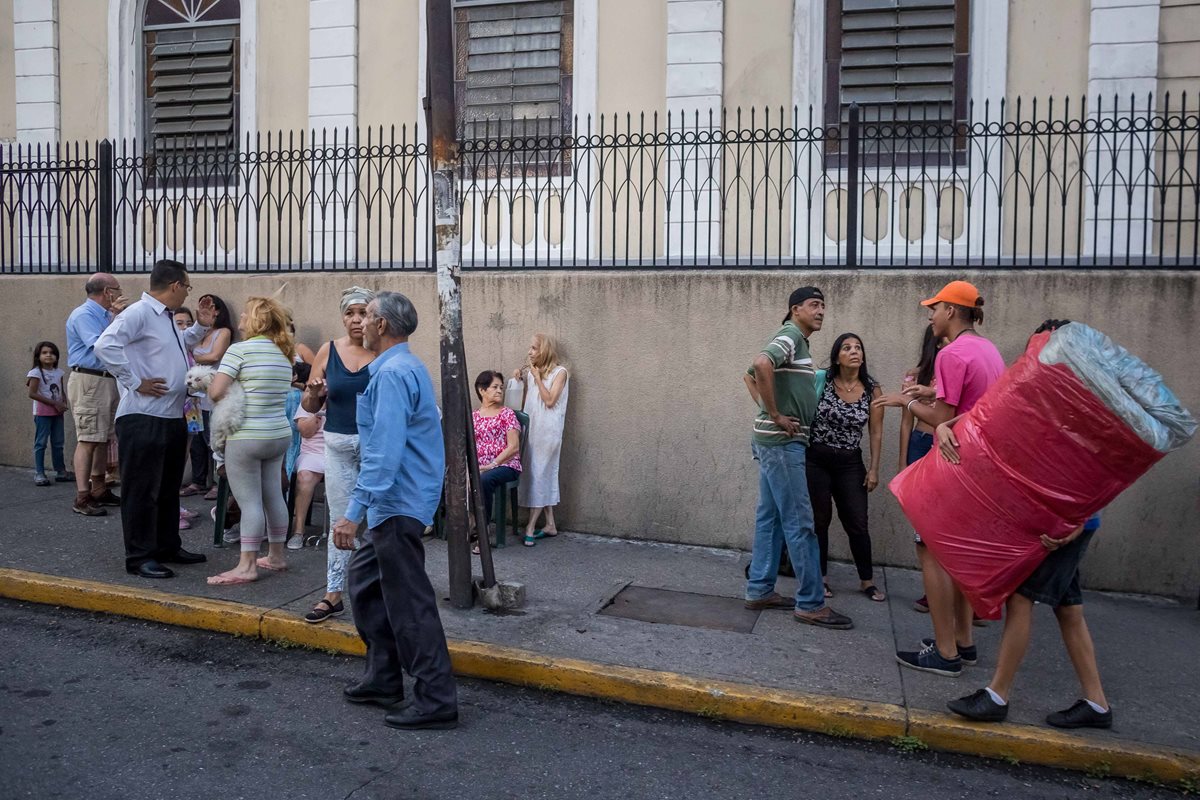 CR008. CARACAS (VENEZUELA), 21/08/2018.- Un grupo de personas permanece en la calle luego de que se registrara un sismo hoy, martes 21 de agosto de 2018, en Caracas (Venezuela). Los venezolanos se vieron hoy estremecidos por un fuerte sismo de magnitud 6,3 con epicentro en el "sureste de Yaguarapano" en el oriente del país, de acuerdo con la Fundación Venezolana de Investigaciones Sismológicas (Funvisis), aunque el Servicio Geológico de EE.UU. reporta una magnitud de 7,0. EFE/Miguel Gutiérrez
