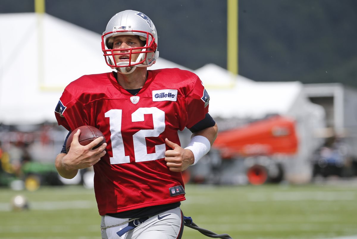 Tom Brady corre con el balón en la práctica de los Patriots y los New Orleans Saints. (Foto Prensa Libre: AP)