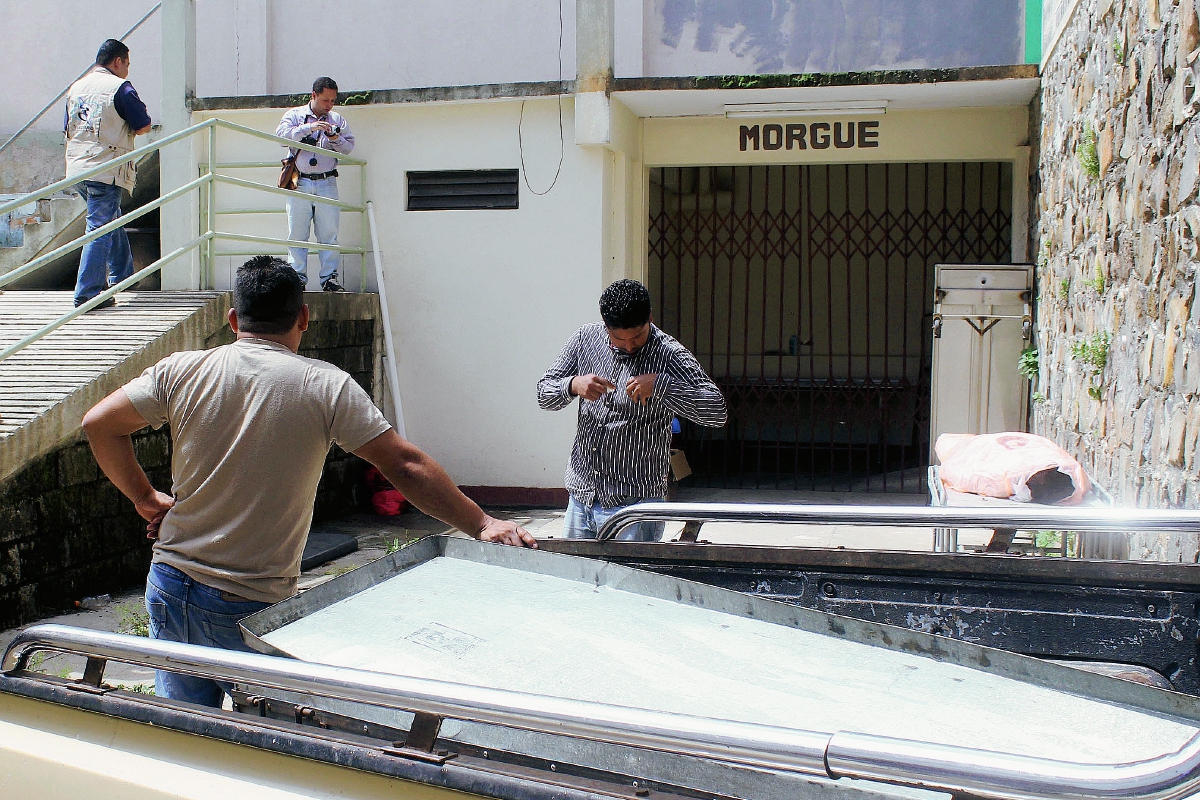 Trabajadores de una funeraria esperan el cadáver de Ramiro Cruz Arias, quien murió baleado en San Pedro Pinula, Jalapa. (Foto Prensa Libre: Hugo Oliva)
