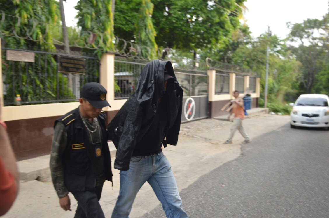 Uno de los agentes detenidos al salir del juzgado. (Foto Prensa Libre: Mario Morales)