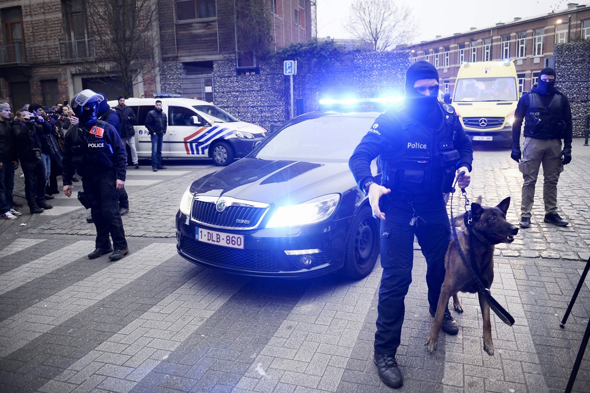 Policías belgas vigilan los alrededores del inmueble donde fue detenido el presunto cerebro de los atentados de París. (Foto Prensa Libre: AFP).