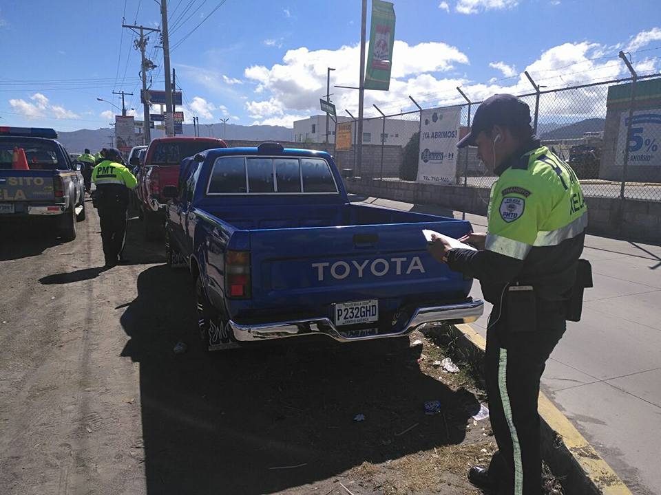 Un agente de la Policía de Tránsito de Xela impone una multa al conductor de un picop por parquearse en un lugar prohibido en la zona 7. (Foto Prensa Libre: PMTQ)