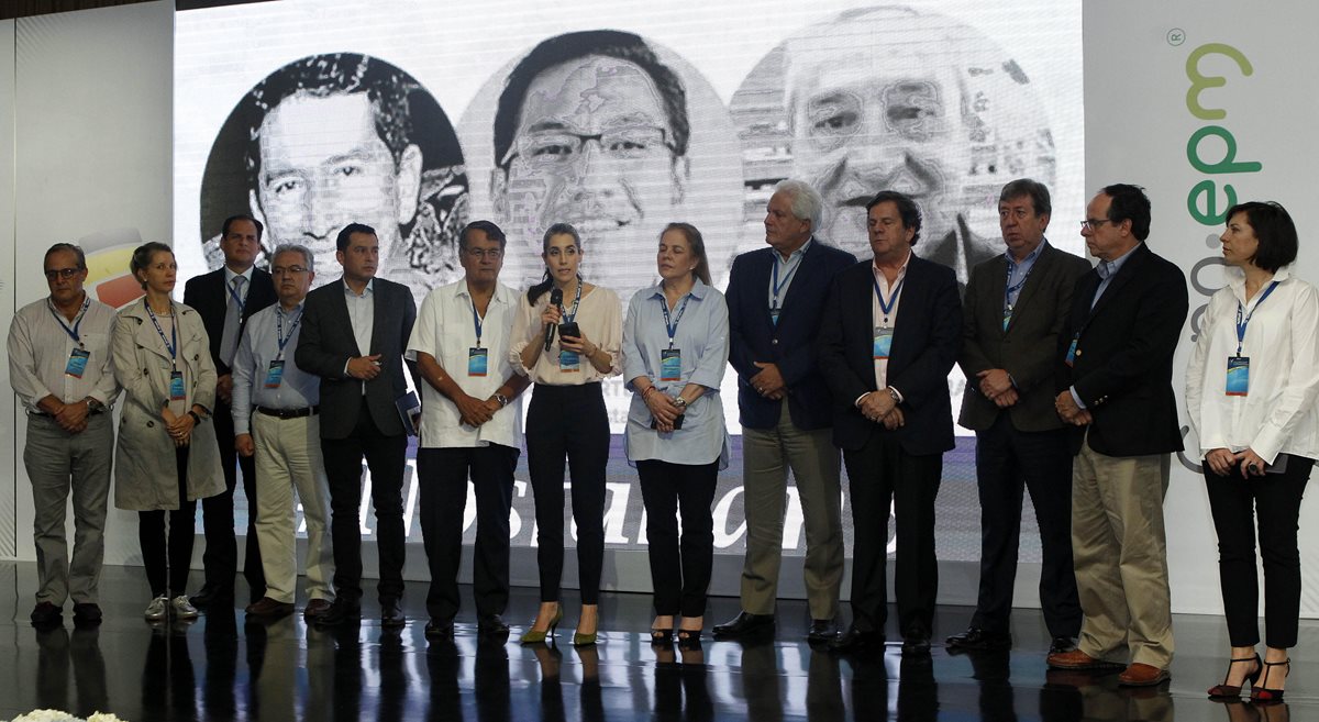 La periodista ecuatoriana Gabriela Vivanco (c) del diario La Hora, donde denuncia la muerte de tres periodistas (al fondo), durante la reunión de la SIP. (Foto Prensa Libre: EFE)
