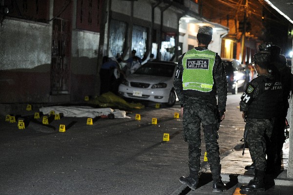 <span>Policías militares</span> <span>hondureños</span> <span>ven en</span> <span>el cuerpo de</span> <span>un hombre muerto en</span> <span>la violencia de pandillas</span><span>.(AFP)</span>