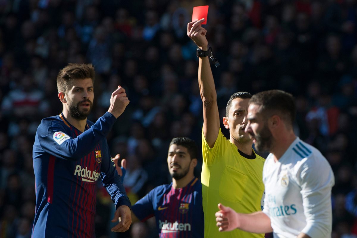 Piqué pide la tarjeta roja para Carvajal luego de que el jugador del Madrid sacara el balón con la mano. (Foto Prensa Libre: AFP)