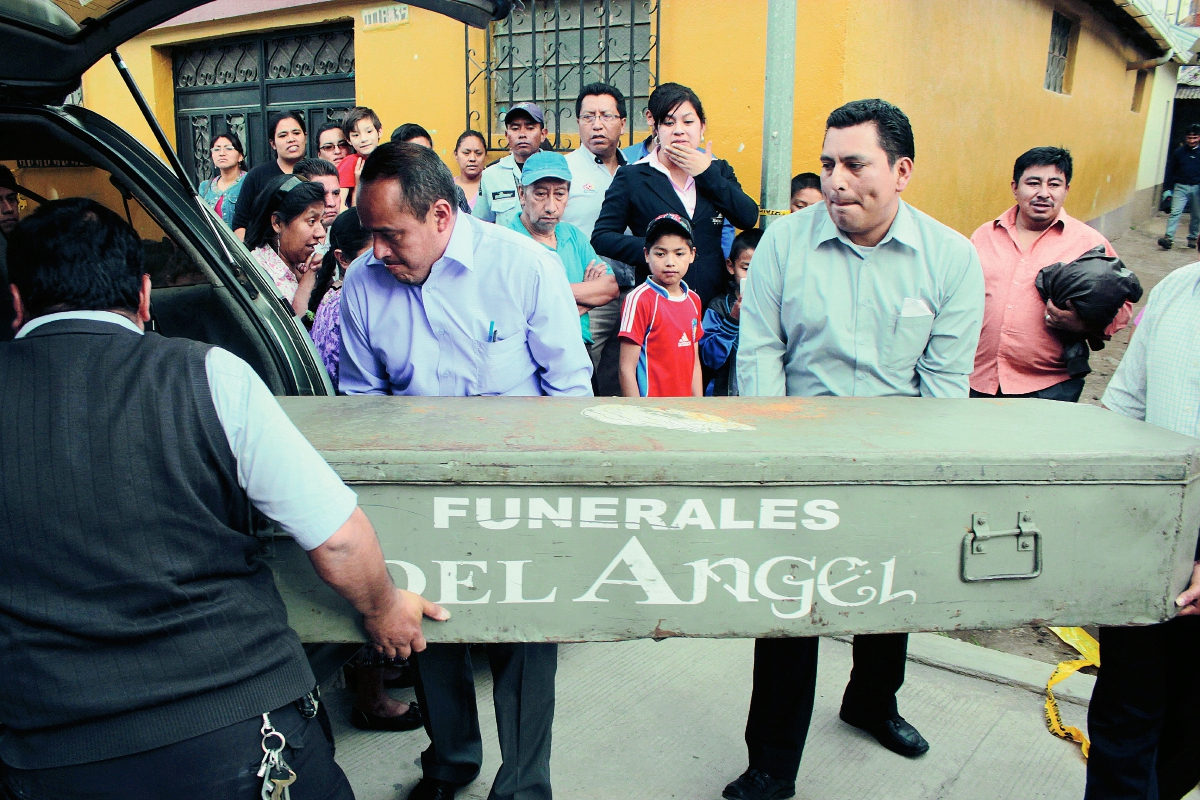 Personal de una funeraria traslada a la morgue el cadáver Wendy Riscajché Pérez, quien fue atacada  con un cuchillo por su hermano, en Quetzaltenango. (Foto Prensa Libre: Carlos Ventura)