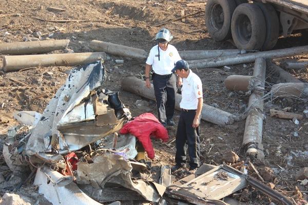 Dos socorristas observan el cabezal que quedó destruido en el kilómetro 63.5 de la carretera a El Salvador, en Cuilapa. (Foto Prensa Libre: Oswaldo Cardona) <br _mce_bogus="1"/>