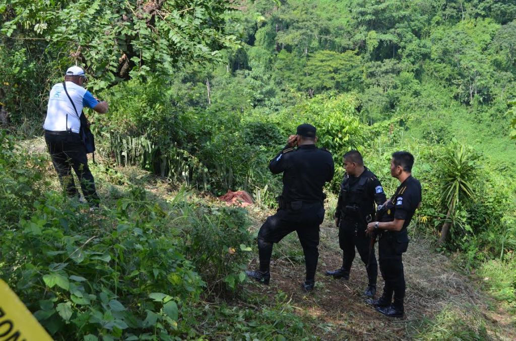 Autoridades inspeccionan el lugar donde quedó el cadáver de una de las víctimas, en El Asintal, Retalhuleu. (Foto Prensa Libre: Jorge Tizol)
