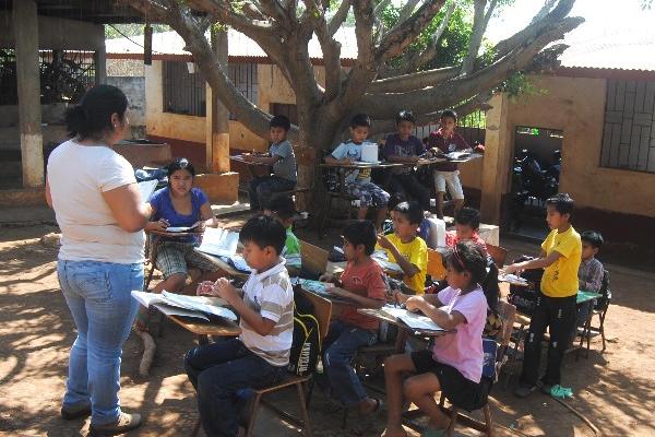 Varios niños de la escuela de la aldea San Agustín Pacayá, Coatepeque, estudian en el patio.